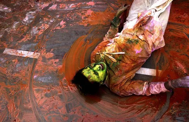 A devotee participates in Holi celebrations at the Nandagram temple, on March 22, 2013. (Photo by Manish Swarup/Associated Press)