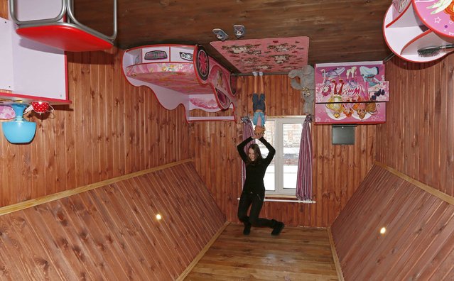 A visitor poses for a picture in a room of a house built upside-down in Russia's Siberian city of Krasnoyarsk, December 14, 2014. (Photo by Ilya Naymushin/Reuters)