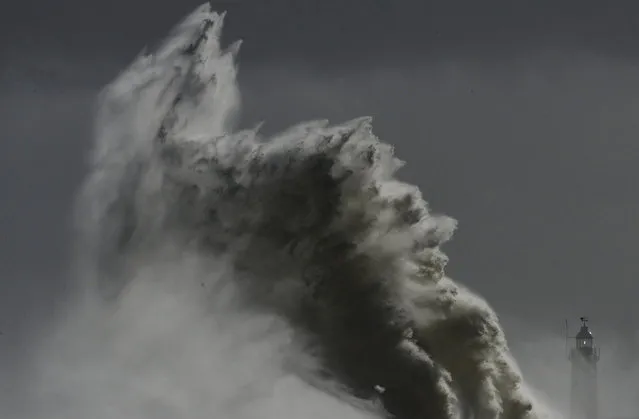 Large waves hit the lighthouse and harbour at high tide at Newhaven in Sussex, southern England, February 15, 2014. (Photo by Toby Melville/Reuters)