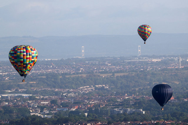 Hot air balloons fly during a mass launch, with the Severn Bridge visible in the background, at the annual Bristol International Balloon Fiesta, in Bristol, Britain, on August 8, 2025. (Photo by Toby Melville/Reuters)