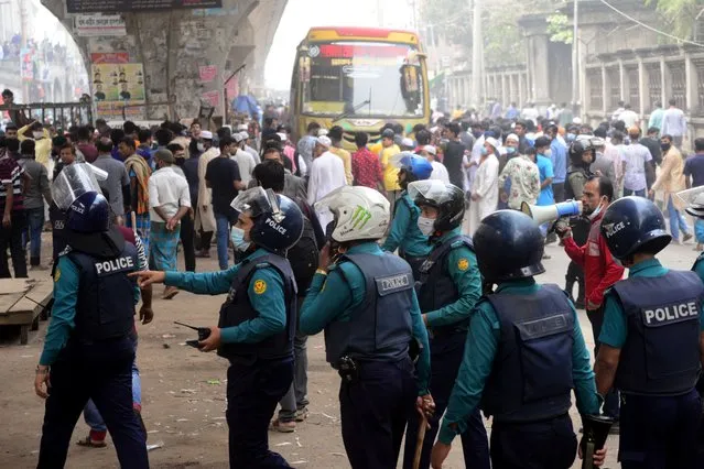 Police baton charge shop owners and salesmen during a clash with police as Dhaka South City Corporation conducts an eviction drive for illegal shops in Dhaka, Bangladesh, on December 8, 2020 (Photo by Mamunur Rashid/NurPhoto via Getty Images)