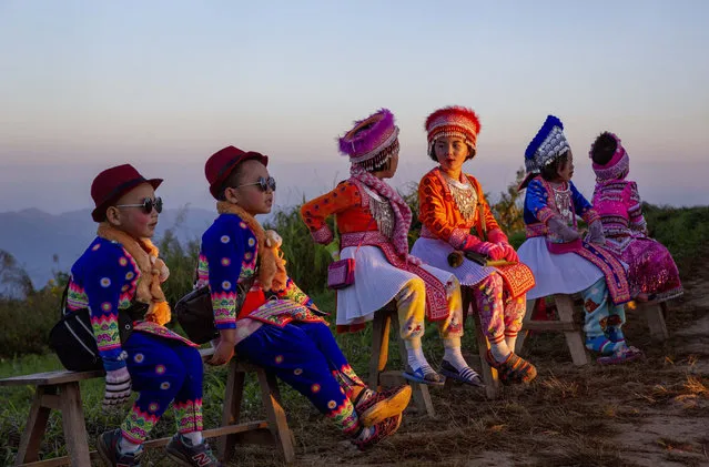 Hill tribe children dressed in traditional attire wait at a mountain viewpoint to pose with tourists at sun rises Phu Chi Fa viewpoint, Chiang Rai, Thailand Friday, November 27, 2020. Domestic tourists have taken advantage of promotions announced by the Thai Government to boost the domestic tourism sector impacted by COVID-19 travel restrictions. (Photo by Gemunu Amarasinghe/AP Photo)