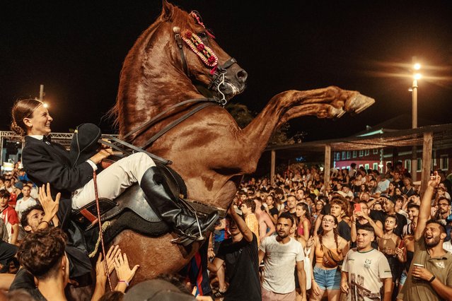 A “caixer” (horse rider) rears up on his horse surrounded by a cheering crowd during the traditional “Jaleo” at the Sant Jaume Festival in Es Castell, Spain on July 24, 2024. (Photo by Matthias Oesterle/Alamy Live News)