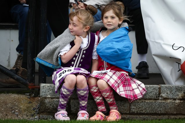 Two dancers keep warm during the Argyllshire Gathering on August 22, 2024 in Oban, Scotland. The Oban Games, a day of intense Highland rivalries and competition, are a key part of the historic Argyllshire Gathering. Founded in 1871, the Gathering began as a way to unite the clans of Argyll – a region encompassing over 20 islands on the western coast of Scotland – through traditional Highland sports. Over time, it has evolved into an annual summer celebration of Scottish heritage and community. (Photo by Jeff J. Mitchell/Getty Images)
