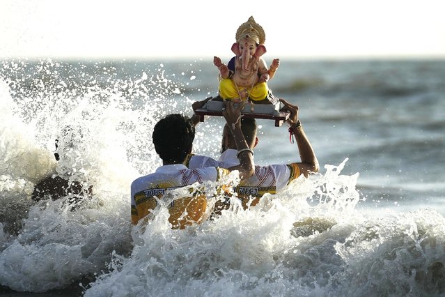 Devotees immerse an idol of elephant-headed Hindu god Ganesha in the Arabian Sea, during the ten days long Ganesh Chaturthi festival in Mumbai, India, Sunday, September 8, 2024. (Photo by Rafiq Maqbool/AP Photo)