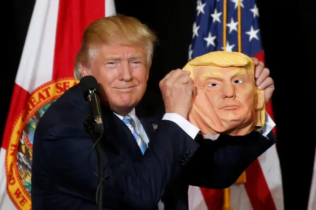 Republican presidential nominee Donald Trump holds up a mask of himself as he speaks during a campaign rally in Sarasota, Florida, U.S. November 7,  2016. (Photo by Carlo Allegri/Reuters)