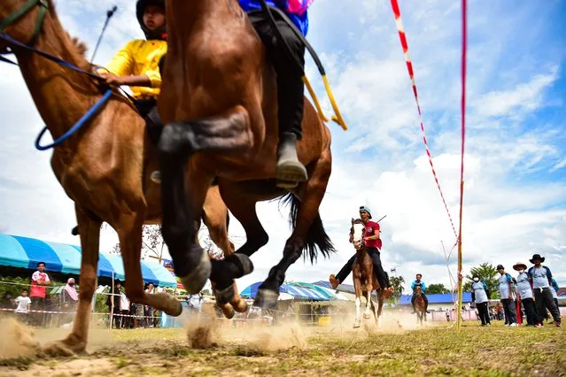 In this picture taken on May 28, 2023, jockeys compete during a traditional horse race in Narathiwat town, southern Thailand. (Photo by Madaree Tohlala/AFP Photo)