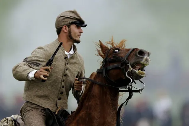 A mounted Confederate reenactor takes part in a demonstration of a battle during ongoing activities commemorating the 150th anniversary of the Battle of Gettysburg, Friday, June 28, 2013, at  at Bushey Farm in Gettysburg, Pa.  Union forces turned away a Confederate advance in the pivotal battle of the Civil War fought July 1-3, 1863, which was also the war s bloodiest conflict with more than 51,000 casualties. (Photo by Matt Rourke/AP Photo)
