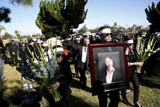 Pallbearers carry a photo of San Bernardino shooting victim Tin Nguyen and her casket during her funeral at Good Shepherd Cemetery in Huntington Beach, California, December 12, 2015. (Photo by Patrick T. Fallon/Reuters)