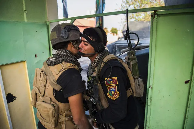 Two soldiers from the Iraqi Special Forces' 2nd division greet each other after reaching a secured building during fighting against Islamic State (IS) group jihadists in the Arbagiah neighbourhood of Mosul on November 12, 2016 Elite Iraqi forces were engaged in “intense” fighting with jihadists in eastern Mosul, an officer said, as civilians gathered on the city' s outskirts to flee Iraqi forces launched a massive operation to retake the country' s second city from the Islamic State group on October 17, and the Counter- Terrorism Service (CTS) special forces have pushed the jihadists back from some Mosul neighbourhoods. (Photo by Odd Andersen/AFP Photo)