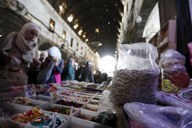 People look at sweets for sale on the occasion of Prophet Mohammad's birthday in Damascus, Syria December 23, 2015. (Photo by Omar Sanadiki/Reuters)