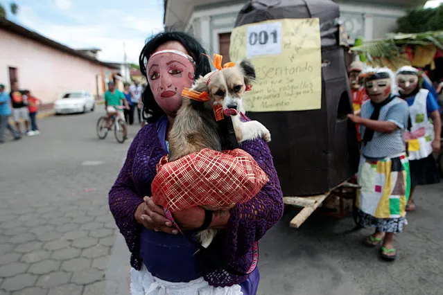 A masked man holds his dog, as he  takes part in festivities in honour of patron saint San Jeronimo in Masaya city, Nicaragua November 20, 2016. (Photo by Oswaldo Rivas/Reuters)