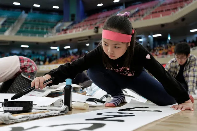 A girl takes part in the New Year calligraphy contest at Nippon Budokan Hall in Tokyo, Japan, 05 January 2016. Over 3,100 people of all ages from across the country participated in the annual new year's event to display their skills in the Japanese calligraphy. (Photo by Kiyoshi Ota/EPA)