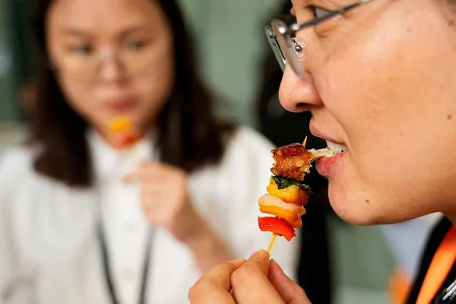 A woman tastes lab-grown meat served by CellX at an event to mark the opening of the cultivated meat company's pilot production facility in Shanghai, China on August 9, 2023. (Photo by Aly Song/Reuters)