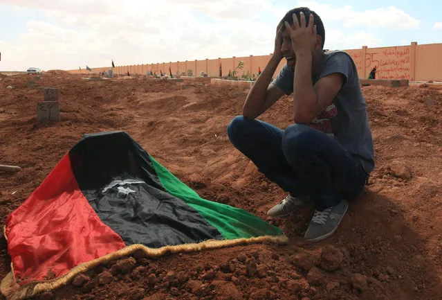 A man reacts over the body of an anti-Gaddafi fighter killed in Sirte by forces loyal to Libyan leader Muammar Gaddafi, in Benghazi October 13, 2011. (Photo by Esam Al-Fetori/Reuters)