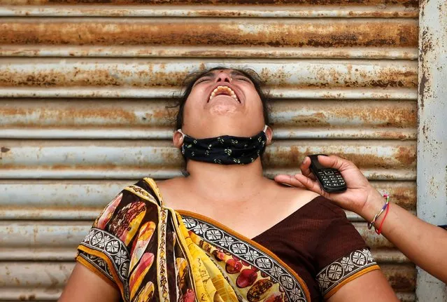 A woman mourns after her husband died due to the coronavirus disease (COVID-19) outside a mortuary of a COVID-19 hospital in Ahmedabad, India, May 8, 2021. (Photo by Amit Dave/Reuters)