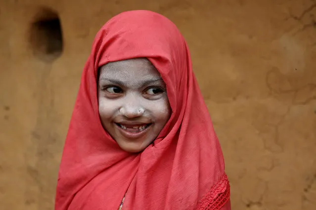 A Rohingya refugee girl smiles as she applies Thanaka paste in the Kutupalong camp in Cox's Bazar, Bangladesh, October 13, 2018. (Photo by Mohammad Ponir Hossain/Reuters)