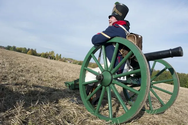 A French soldier sits on an artillery piece during a re-enactement of the Battle of the Nations (Voelkerschlacht) in Leipzig October 20, 2013. This year's re-enactement marks the battle's 200th anniversary, with 6.000 enthusiasts taking part. The battle, between the remnants of Napoleon's Grande Armee and a Russo-Prussian coalition, was Napoleon's most crushing defeat. (Photo by John Macdougall/AFP Photo)