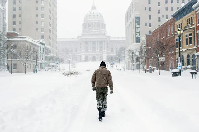 A pedestrian walks near the state Capitol Saturday, January 23, 2016, in Harrisburg, Pa. A massive winter storm buried much of the U.S. East Coast in a foot or more of snow by Saturday, shutting down transit in major cities, stranding drivers on snowbound highways, knocking out power to tens of thousands of people. (Photo by James Robinson/PennLive.com via AP Photo)
