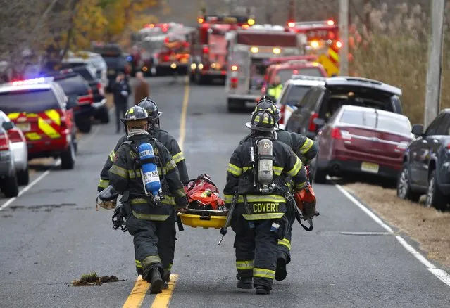 Firefighters carry a stretcher to the scene of a fatal fire at 15 Willow Brook Rd. Tuesday, November 20, 2018, in Colts Neck,N.J. Authorities say two adults and two children were found dead at the scene of a burning mansion near the New Jersey shore. Monmouth County prosecutor Christopher Gramiccioni says the fire continues to burn late Tuesday afternoon at the two-story home in Colts Neck. He says one body was found out front. He is not yet identifying the victims. (Photo by Noah K. Murray/AP Photo)