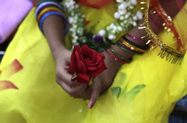 A young Hindu girl holds a rose in her hand during a ceremony where she and other girls are worshipped as “Kumari”, or living goddess, during Ram Navami festival, at a temple in Kolkata, India, Saturday, March 28, 2015. (Photo by Bikas Das/AP Photo)