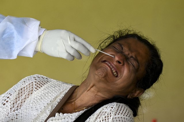 A resident reacts as a health worker collects a swab sample to test for the Covid-19 coronavirus in Colombo on July 27, 2021. (Photo by Ishara S.  Kodikara/AFP Photo)
