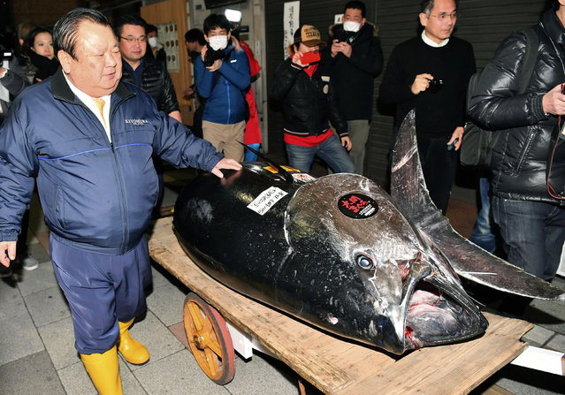 Kiyomura Corp. owner Kiyoshi Kimura, left, stands near the bluefin tuna which he made a wining bid at the annual New Year auction, in Tokyo Saturday, January 5, 2019. The 612-pound (278-kilogram) bluefin tuna sold for a record 333.6 million yen ($3 million) in the first auction of 2019, after Tokyo's famed Tsukiji market was moved to a new site on the city's waterfront. (Photo by Koki Sengoku/Kyodo News via AP Photo)