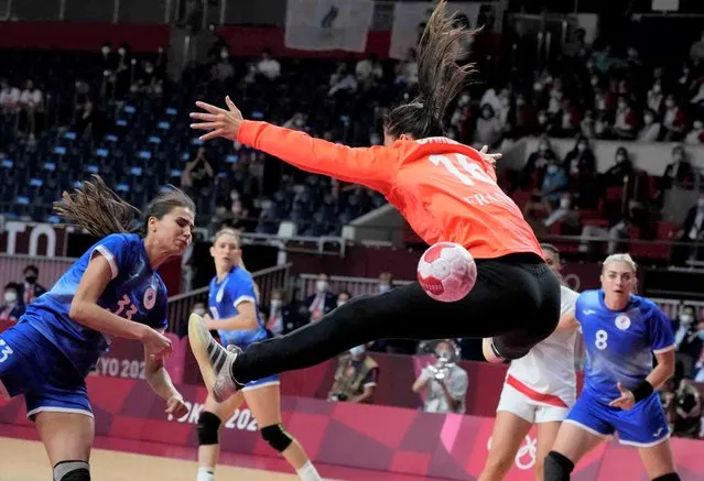 Ekaterina Ilina, of the Russian Olympic Committee, scores a goal past France's goalkeeper Cleopatre Darleux during the women's gold medal handball match between the Russian Olympic Committee and France at the 2020 Summer Olympics, Sunday, August 8, 2021, in Tokyo, Japan. (Photo by Sergei Grits/AP Photo)