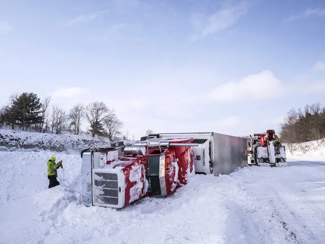 Tow truck personnel work to remove an overturned semi in the median of Interstate 90 at mile marker 218 near the U.S. Highway 52 exit Monday, January 28, 2019, southeast of Rochester, Minn. According to Sgt. Troy Christianson, with the Minnesota State Patrol, the semi was eastbound and went straight off the gradual curve into the median because of blowing snow. Sgt. Christianson said there were no injuries in the crash. (Photo by Joe Ahlquist/The Rochester Post-Bulletin via AP Photo)
