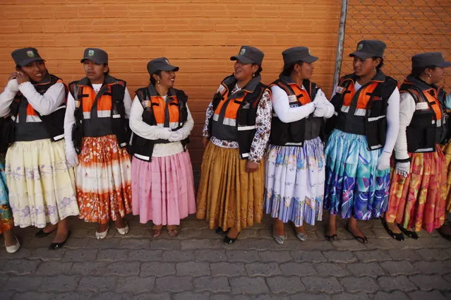 In this November 28, 2013 photo, Aymara women traffic cops speak during a training session before heading out to control the vehicular traffic on the streets of El Alto, Bolivia. (Photo by Juan Karita/AP Photo)