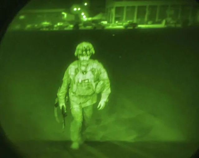 In this image made through a night vision scope and provided by U.S. Central Command, Maj. Gen. Chris Donahue, commander of the U.S. Army 82nd Airborne Division, XVIII Airborne Corps, boards a C-17 cargo plane at the Hamid Karzai International Airport in Kabul, Afghanistan, Monday, August 30, 2021, as the final American service member to depart Afghanistan. (Photo by U.S. Central Command via AP Photo)