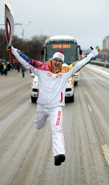 A handout picture taken during the Sochi 2014 Winter Olympic torch relay on January 22, 2014, and released by the Sochi 2014 Winter Olympics Organizing Committee shows a torchbearer jumping with an Olympic torch in the city of Rostov-on-Don, some 1,000 km (600 miles) south of Moscow. (Photo by AFP Photo/Sochi 2014 Organizing Committee)