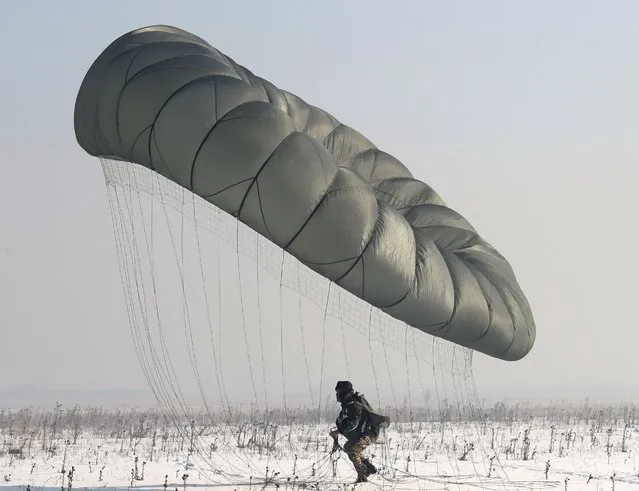 A Kyrgyz military parachuter lands during a planned exercise of special forces units of the Armed Forces of the Kyrgyz Republic, in Bishkek, Kyrgyzstan, 14 December 2022. More than 80 military personnel of Kyrgyzstan made parachute jumps to improve landing skills in various conditions. (Photo by Igor Kovalenko/EPA/EFE/Rex Features/Shutterstock)