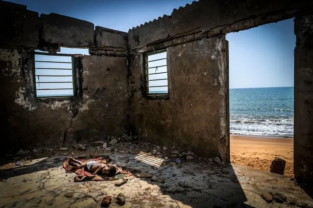 Environmental photographer of the year: The Rising Tide Sons – Togo, West Africa, 2019. A child sleeps on the floor of his house about to collapse, destroyed by coastal erosion on Afidegnigba beach. Sea levels off the coast of Togo and other West African countries continue to rise and swallow up everything in their path, affecting more than 4,900 miles (8,000km) of seacoast in 13 West African countries. Rising sea levels are forcing the ocean floor to readjust by removing sediment from the coast, washing it away from the shore. (Photo by Antonio Aragon Renuncio/CIWEM Environmental Photographer of the Year 2021)