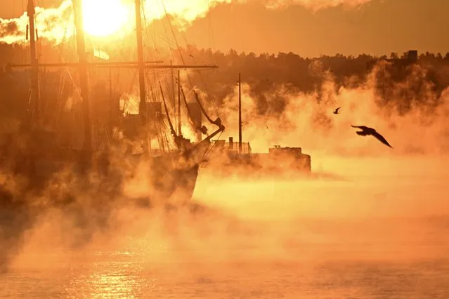Vapour rises from the water around a historic tri-master charter sailing ship moored in a port of Oslo on January 5, 2024, as morning sun paints the scene in golden light during unusual cold temperatures around –22 degrees Celsius in the Norwegian capital. (Photo by Olivier Morin/AFP Photo)