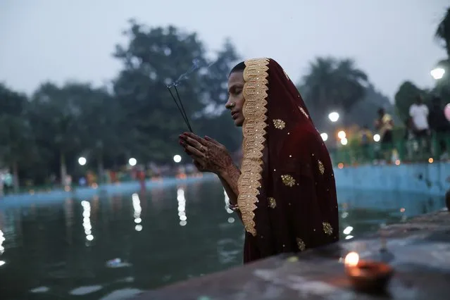 A Hindu woman worships the Sun god in a pool at a park during the religious festival of Chhath Puja in New Delhi, India, November 10, 2021. (Photo by Anushree Fadnavis/Reuters)