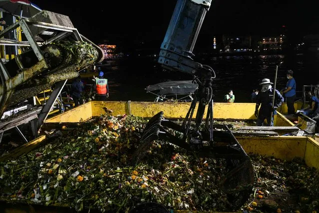 Bangkok district workers collect krathongs (floating baskets) from the Chao Phraya river after the Loy Krathong festival, which is held as a symbolic apology to the goddess of the river in Bangkok, Thailand, November 19, 2021. (Photo by Soe Zeya Tun/Reuters)