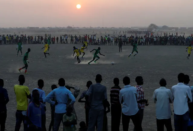 People watch a football match in the United Nations Mission in South Sudan (UNMISS) Protection of Civilian site (CoP), near Bentiu, northern South Sudan, February 6, 2017. (Photo by Siegfried Modola/Reuters)