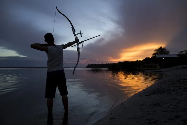 Kambeba Indian, Dream Braga, 18, poses for a picture during sunset on the banks of the Negro river at the village Tres Unidos, Amazon state, May 9, 2015. (Photo by Bruno Kelly/Reuters)