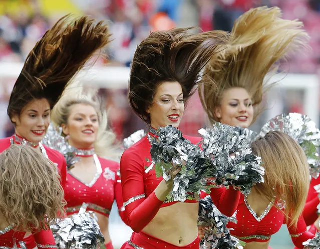 Cheerleaders let their hair fly as they perform prior to a German first division Bundesliga soccer match between 1. FC Cologne and Bayern Munich in Cologne, Germany, March 4, 2017. (Photo by Michael Probst/AP Photo)