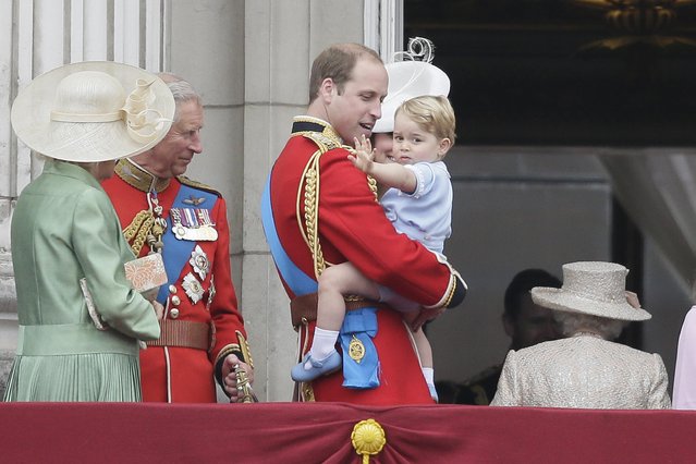 Britain's Prince William holds his son Prince George as they leave the balcony following the Trooping The Colour parade at Buckingham Palace, in London, Saturday, June 13, 2015. Hundreds of soldiers in ceremonial dress have marched in London in the annual Trooping the Color parade to mark the official birthday of Queen Elizabeth II. The Trooping the Color tradition originates from preparations for battle, when flags were carried or "trooped" down the rank for soldiers to see. (AP Photo/Tim Ireland)