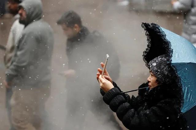 A woman photographs snow as it falls in New York, U.S., January 31, 2017. (Photo by Lucas Jackson/Reuters)