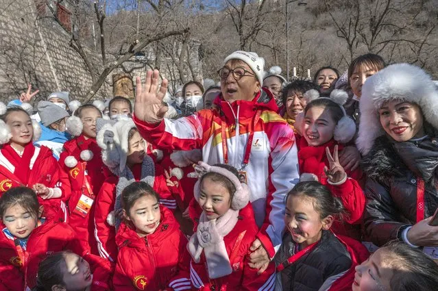 Actor Jackie Chan reacts as he poses with student performers after participating in a leg of the Beijing 2022 Winter Olympics Torch Relay at the Badaling Great Wall on February 3, 2022 outside Beijing, China. (Photo by Kevin Frayer/Getty Images)