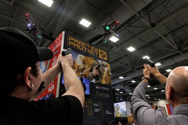 People practice their shot with laser technology at an exhibition booth during the annual National Rifle Association (NRA) meeting in Dallas, Texas, U.S., May 18, 2024. (Photo by Shelby Tauber/Reuters)