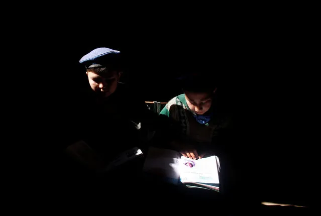 Ethnic Hazara children study in their home in Turkman camp in Nowshera, Pakistan February 9, 2017. (Photo by Fayaz Aziz/Reuters)