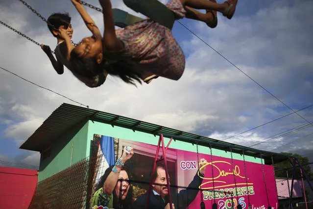 In this November 4, 2016 file photo, children swing in a park next to an election billboard promoting Nicaragua's President Daniel Ortega and running mate, his wife Rosario Murillo in Managua, Nicaragua. Nicaraguan opposition leaders returned to the negotiating table Wednesday, July 31, 2019, at a business center where talks on resolving the country's political crisis stalled months ago, but there was nobody there to talk to. The opposition wants Ortega, 73, to negotiate electoral reform and early elections. (Photo by Esteban Felix/AP Photo/File)