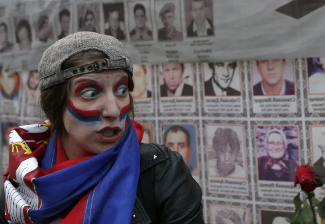 A girl with her face painted as the Serbian flag participates during a protest against Serbian Prime Minister Aleksandar Vucic, in Belgrade, Serbia, Wednesday, April 5, 2017. The protesters have for the third day gathered on the streets after calls on social media to rally against his “dictatorship”. (Photo by Darko Vojinovic/AP Photo)