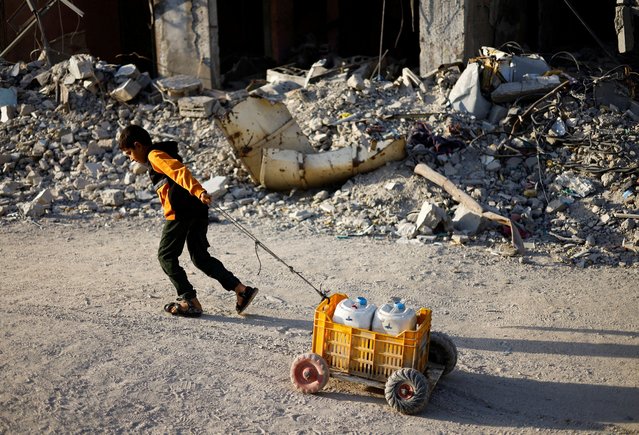 A Palestinian child pulls water containers, amid the ongoing conflict between Israel and Hamas, in southern Gaza City, in the Gaza Strip on June 3, 2024. (Photo by Mohammed Salem/Reuters)