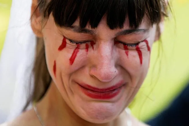 A woman with fake blood on her face reacts during a demonstration of Ukrainians and their supporters outside the Russian Embassy, after Russia launched a massive military operation against Ukraine, in Mexico City, Mexico on February 26, 2022. (Photo by Luis Cortes/Reuters)