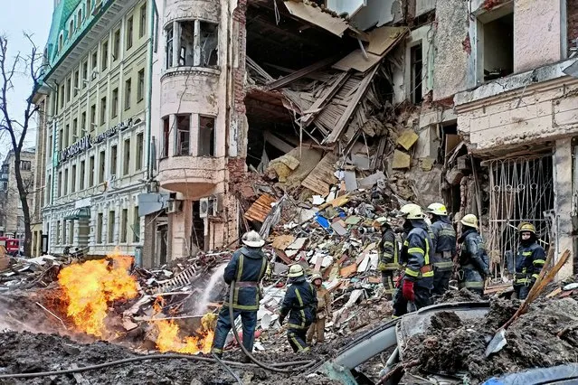 Rescuers work next to a building damaged by air strike, as Russia's attack on Ukraine continues, in central Kharkiv, Ukraine on March 14, 2022. (Photo by Vitalii Hnidyi/Reuters)